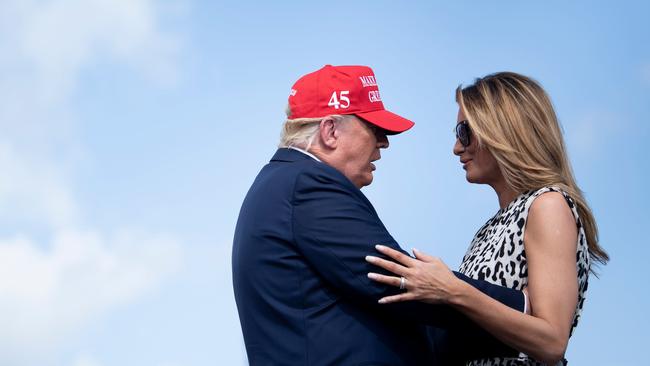 US President Donald Trump and US First Lady Melania Trump embrace during a rally at Raymond James Stadium's parking lot on October 29 in Tampa, Florida. Picture: AFP