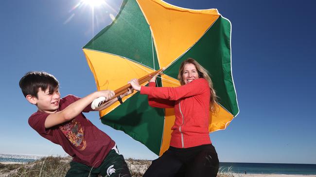 Gold Coaster Meg Kelly and her son Julian, 9, battle the windy conditions at Tugun. Picture: Jason O'Brien