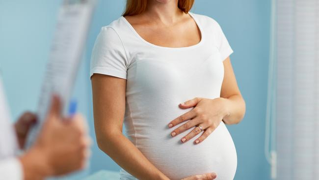 Pregnant woman with hands on stomach talking to obstetrician Picture: iStock