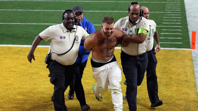 Security remove the man from the field. (Photo by Harry How / GETTY IMAGES NORTH AMERICA / Getty Images via AFP)