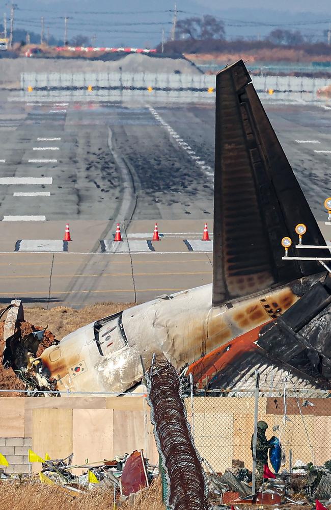 The wrecked tail section of the Jeju Air Boeing 737-800 aircraft that crashed and burst into flames is seen at the end of the runway at Muan International Airport. Picture: AFP