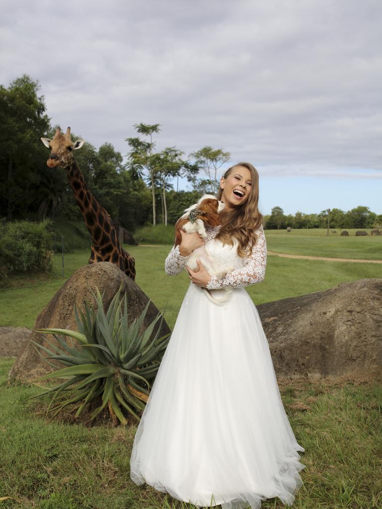 Bindi Irwin holds her dog “Piggy” with giraffe in the background. Picture: Kate Berry