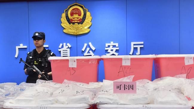 A policeman standing guard next to bags of cocaine seized in Guangzhou in China's southern Guangdong province. Picture: AFP