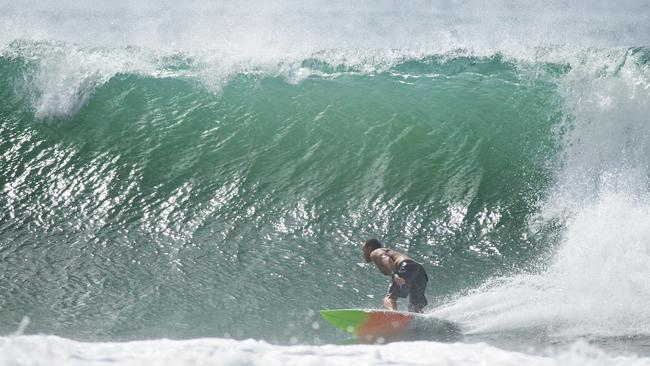 A surfer at Maroochydore as a large swell hits southeast Queensland. Picture Lachie Millard