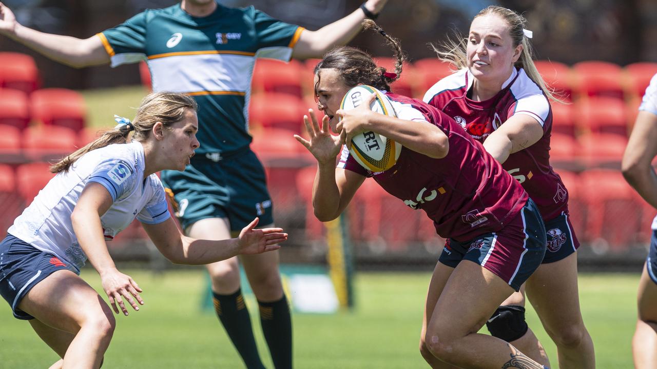 Ava Wereta with the ball for Queensland Reds looks to avoid a tackle from Piper Simons of New South Wales Waratahs as Downs Rugby at host Next Gen 7s at Toowoomba Sports Ground, Saturday, October 12, 2024. Picture: Kevin Farmer