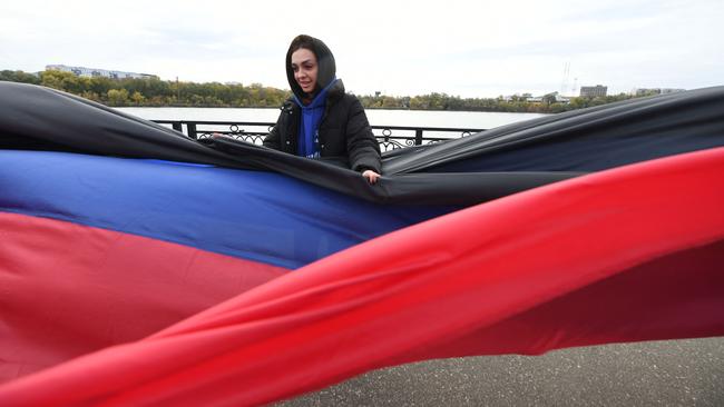 Activists unfold a giant flag of the Donetsk People's Republic, to mark the Flag Day in Donetsk, Russian-controlled Ukraine, on Friday. Picture: AFP