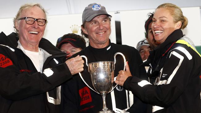 The owner of line honours winner Comanche, Jim Clark, skipper Ken Read and Clark’s wife, Australian Kristy Hinze, with the winner’s trophy in Hobart on Monday night.