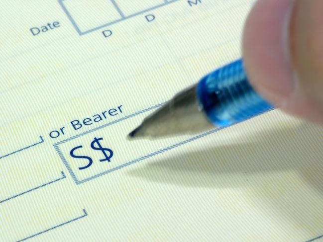 Generic photo of a person writing a cheque. Picture: iStock