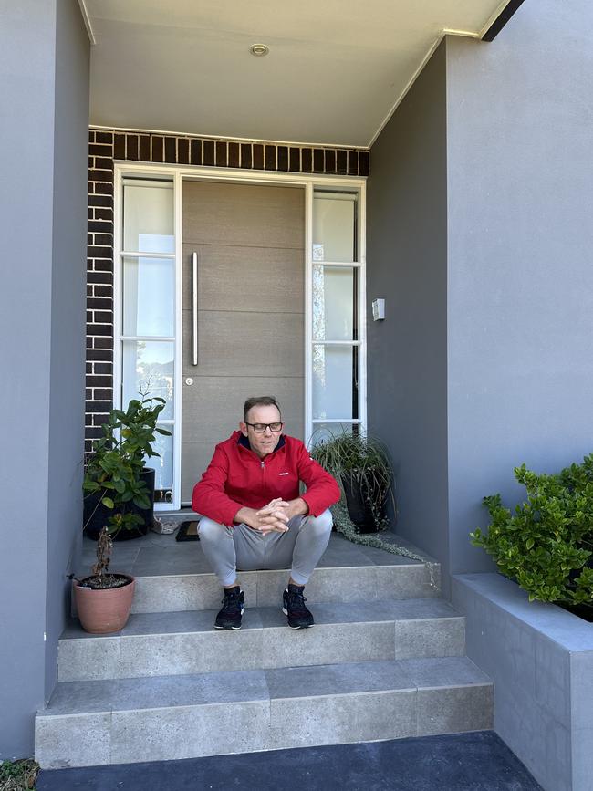 Mike Arnold sitting on the steps of the rental property he stopped paying for.