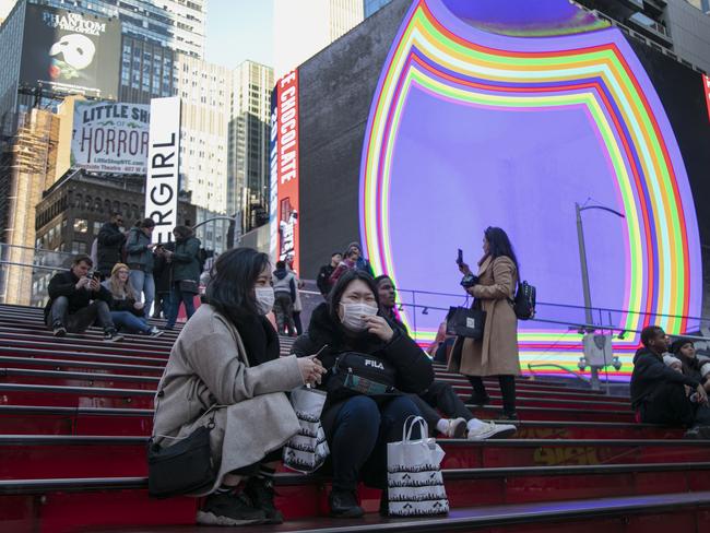 Japanese tourists wear face masks as they sit and chat in Times Square in New York. Picture: AP