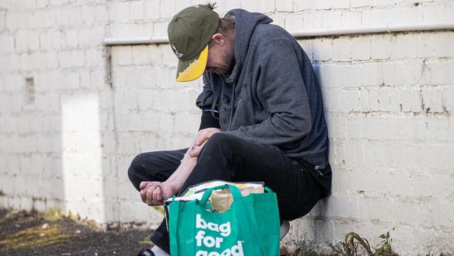 A man blatantly injects drugs on a streets in Richmond. Picture: Jason Edwards