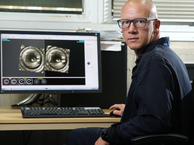 Scientific Officer Elton Potgieter analysing bullet shells at the Sydney Police Headquarters in Surry Hills. Picture: Tim Hunter.