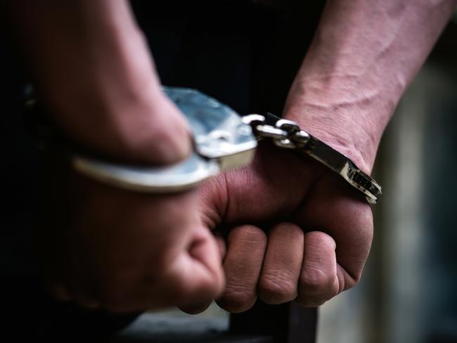 Man on the chair in Handcuffs. Rear view and Closeup ,Men criminal in handcuffs arrested for crimes. With hands in back,boy  prison shackle in the jail violence concept.