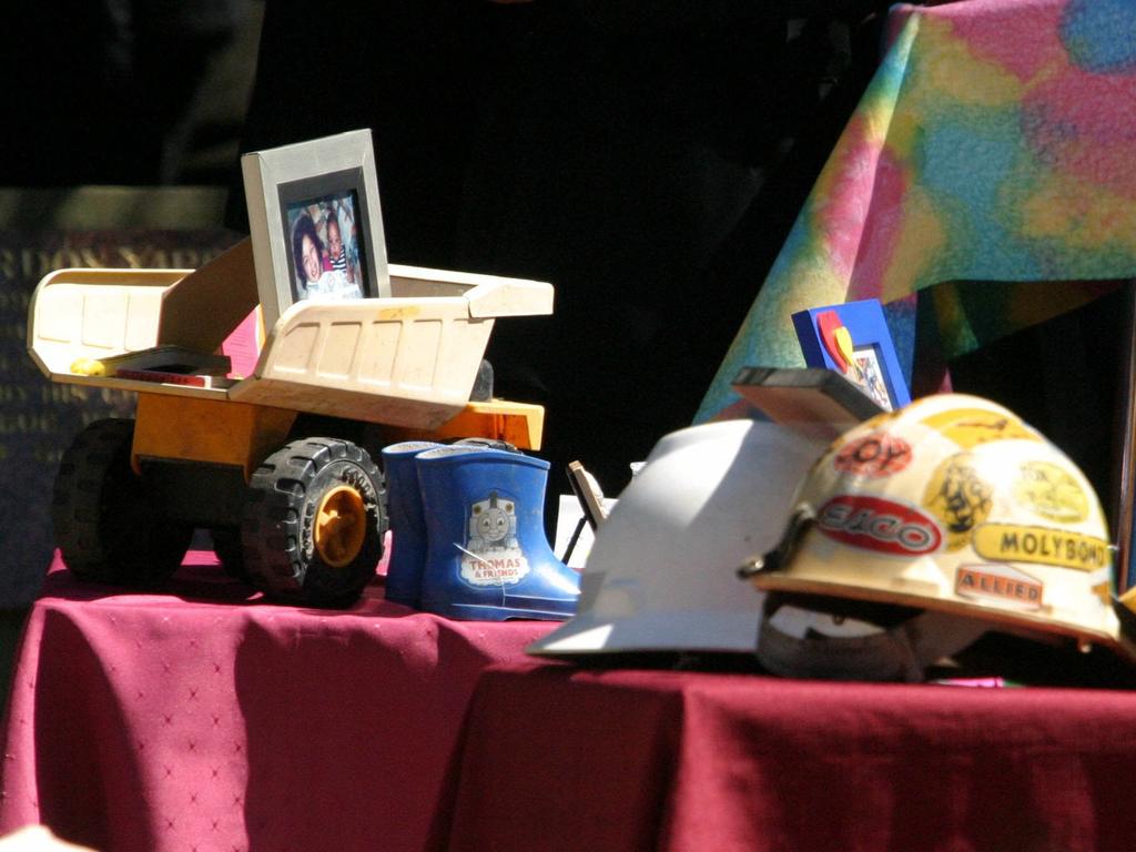 Bas and Malee’s tractor and galoshes and Peter Poulson’s RFS helmet on their coffins at the funeral. Picture: Scott Hornby.