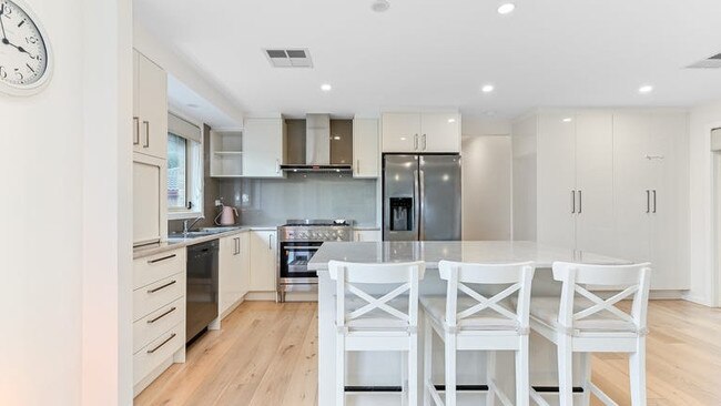 In the kitchen, there’s three-seater breakfast island, polished rounded-edge laminate countertops and large tiled splashback.