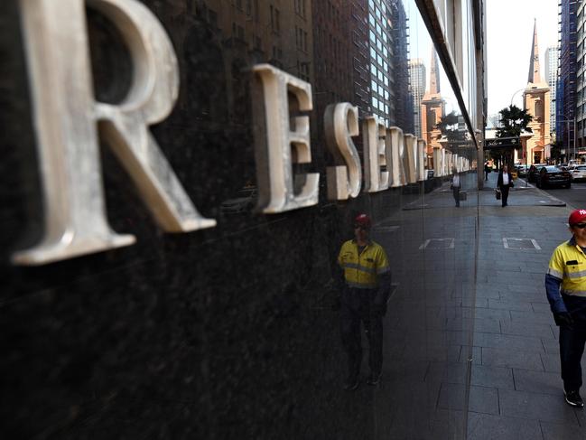 People walk past the Reserve Bank of Australia building in Sydney on October 1, 2019. - Australia's central bank lowered the cost of borrowing, slashing interest rates for the third time this year amid fears about the flagging domestic economy. (Photo by Saeed KHAN / AFP)