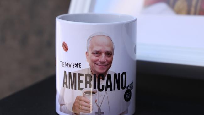 A portrait of new Pope Leo XIV adorns a coffee cup with the word 