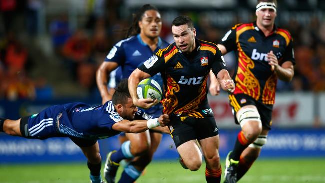 Tom Marshall of the Chiefs breaks the tackle of Jamison Gibson-Park of the Blues.