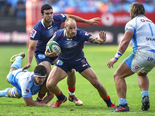 Rebels' Billy Meakes (2nd R) runs as Bulls' Marco van Staden (L) dives to tackle him during the Super Rugby rugby union match between South Africa's Bulls and Australia's Rebels at the Loftus Versfeld Stadium in Pretoria on April 21, 2018. / AFP PHOTO / Christiaan Kotze