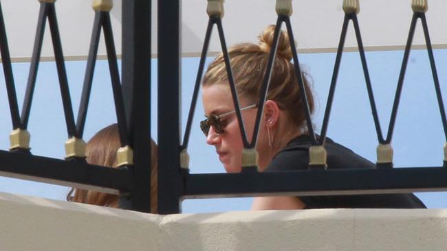 Amber Heard and an unidentified woman unwind on the rooftop terrace of a luxury condo at Palazzo Versace. Picture Mike Batterham