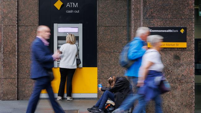 SYDNEY, AUSTRALIA - NewsWire Photos MAY 10 2024. GENERIC. A woman begs for money next to a Commonwealth Bank ATM in Sydney. Economy, cost of living, budget, poverty, homeless, banking. Picture: NCA NewsWire / Max Mason-Hubers