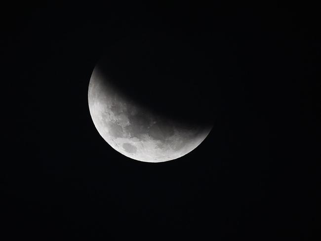 The moon enters the earth’s shadow to begin a partial lunar eclipse near Perth. Picture: AFP