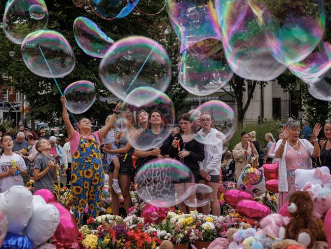 Members of the community blow bubbles as people gather to mourn victims of last week's knife attack by holding a vigil near the Atkinson in Southport, England. Picture: Getty Images