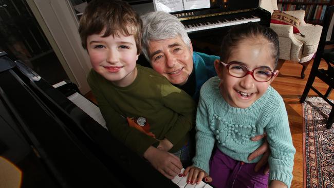 Daphne Proietto has been nominated for an Inspiration Medal for giving children with disabilities free piano lessons. Children who take her classes, which she takes at her home after her full-time job as a music teacher, show remarkable progress. Daphne with Marco Orkibi, 8, on the left, who has Autism, and Aban Bazldjou, 7, on the right who has Cerebral Palsy. Picture: Alex Coppel.