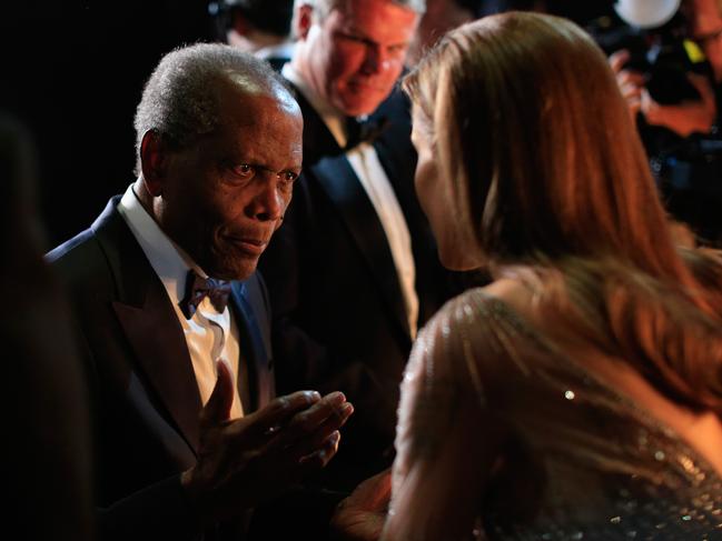 Sidney Poitier and Angelina Jolie speak backstage during the Oscars held at Dolby Theatre on March 2, 2014 in Hollywood, California. Picture: Christopher Polk/Getty Images.