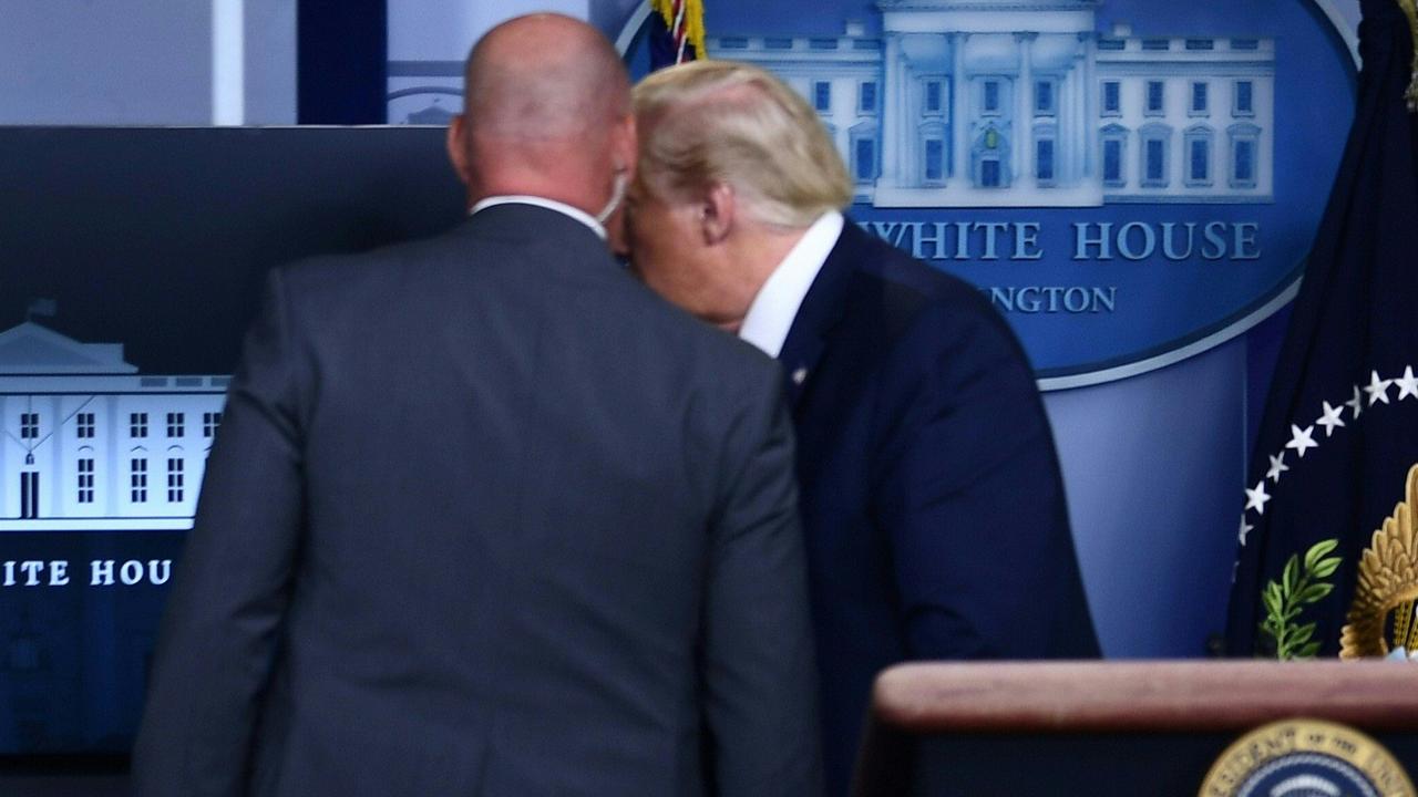 The agent spoke into the President’s ear. Picture: Brendan Smialowski / AFP