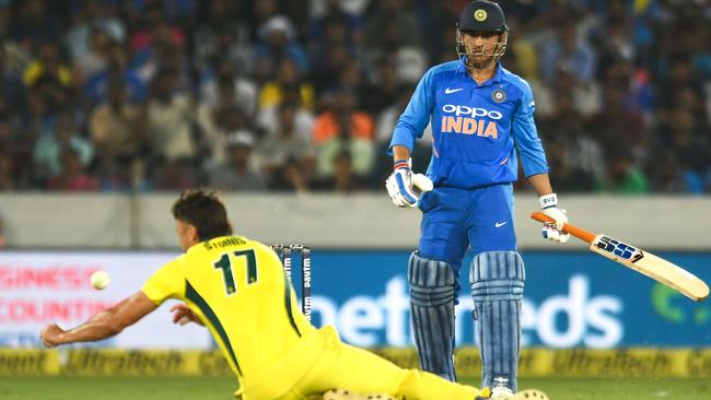 Indian cricketer Mahendra Singh Dhoni (R) plays a shot as Australian bowler Marcus Stoinis (L) tries to catch during the first one day international (ODI) cricket match between India and Australia at the Rajiv Gandhi International Cricket Stadium in Hyderabad on March 2, 2019. (Photo by NOAH SEELAM / AFP) / ----IMAGE RESTRICTED TO EDITORIAL USE - STRICTLY NO COMMERCIAL USE----- / GETTYOUT