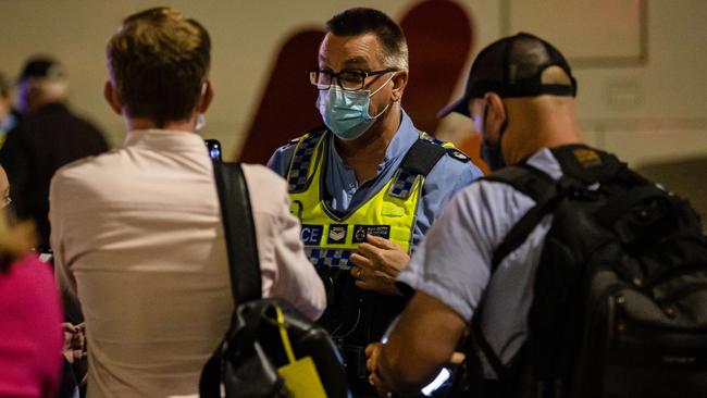 Police check media Covid passports thoroughly as they offload a plane in WA. Picture: Jason Edwards