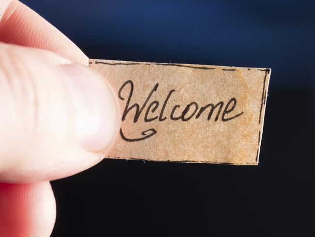 'welcome' hand lettering, hand holding a tag "welcome"