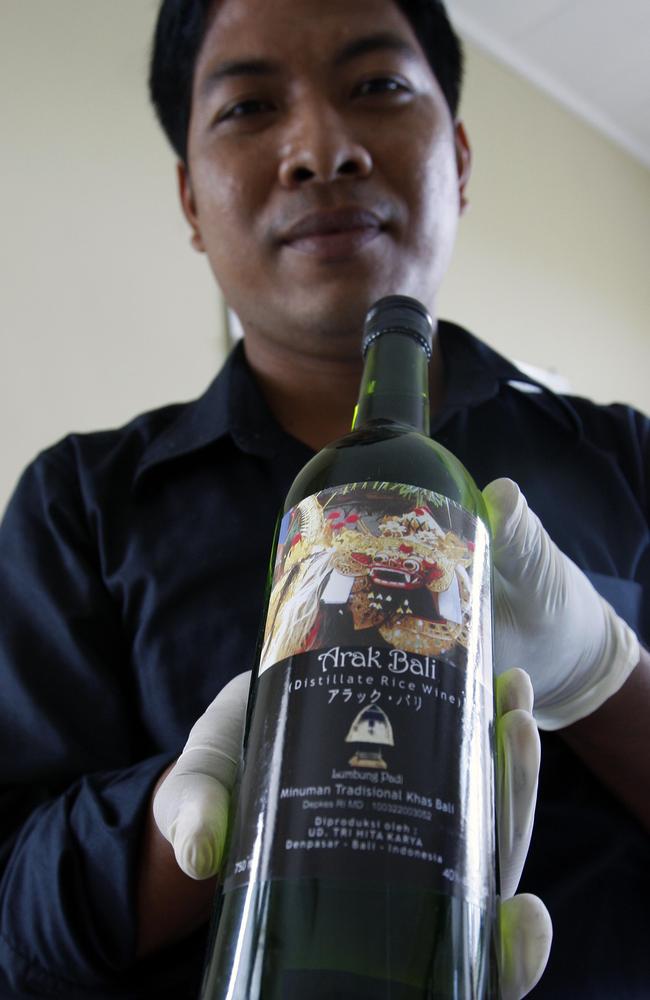 A Bali policeman shows one of the three Arak brands. Picture: News Corp