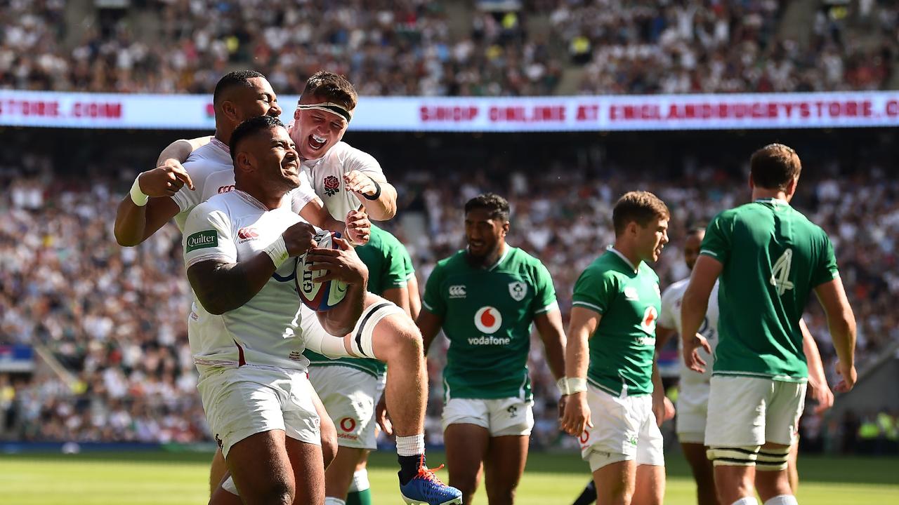 England's centre Manu Tuilagi (2nd L) celebrates after scoring in their rout over Ireland.