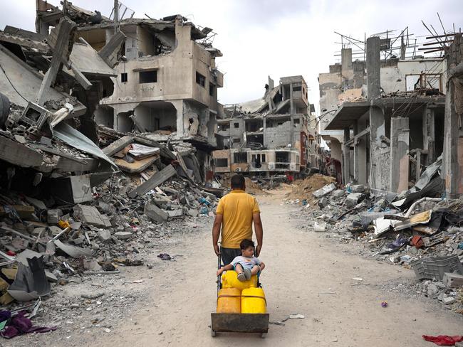 A Palestinian man pulls a cart on a road lined with destroyed buildings in Khan Yunis in the southern Gaza Strip. Picture: AFP