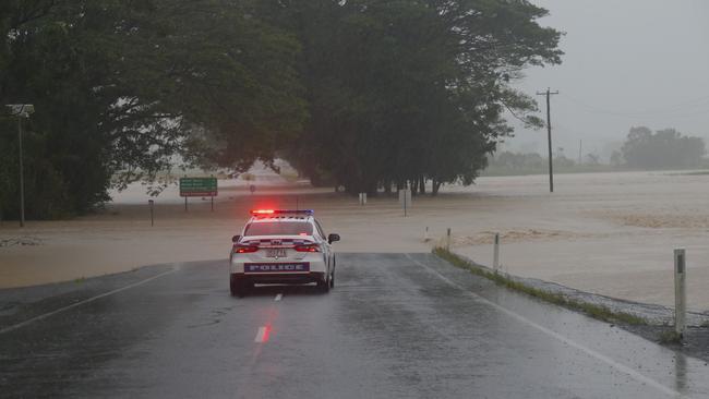 A police car blocks access to the flooded Mossman River. Picture: Peter Carruthers