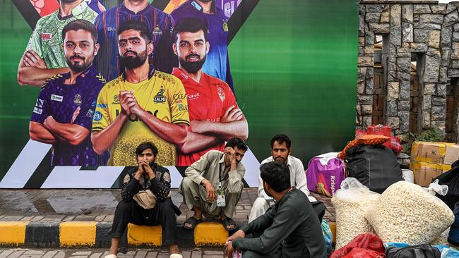 Vendors pack their belongings as they leave Rawalpindi Cricket Stadium following the postponement of the Pakistan Super League (PSL) match after the alleged shooting of a drone. (Photo by Aamir QURESHI / AFP)