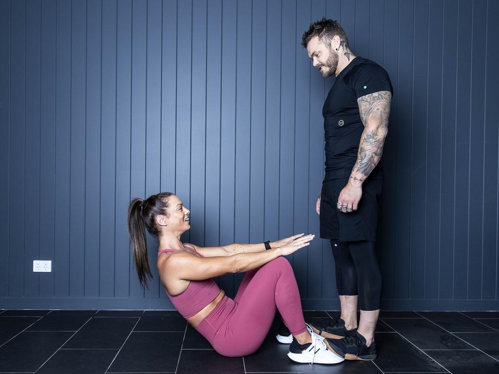 Jenna Louise’s partner Scott Evennett provides some resistance for her crunches. Picture: Gary Ramage