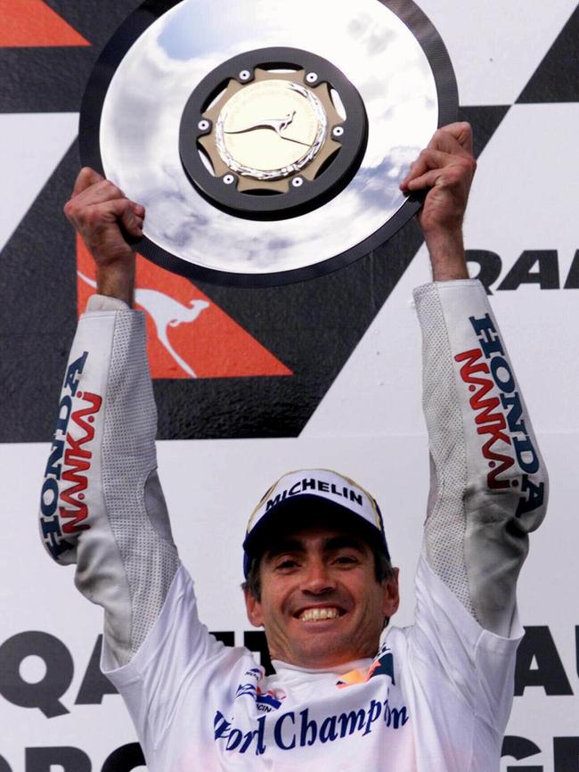 World champion Mick Doohan holding the winner's trophy above head after winning the 1998 Australian Motorcycle Grand Prix.