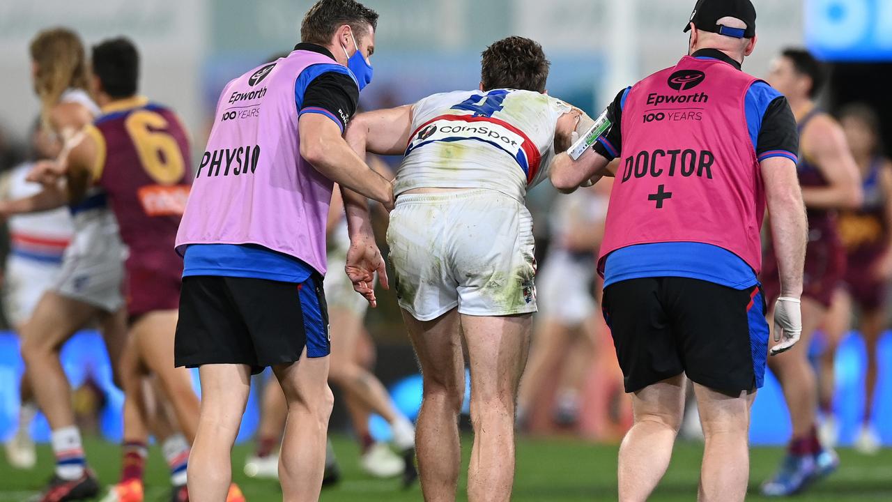 Marcus Bontempelli is helped from the ground against Brisbane. Picture: Bradley Kanaris/Getty Images