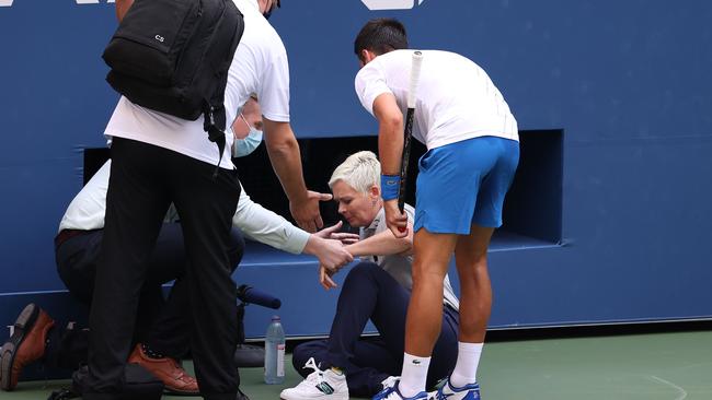 Novak Djokovic of Serbia tends to a lineswoman