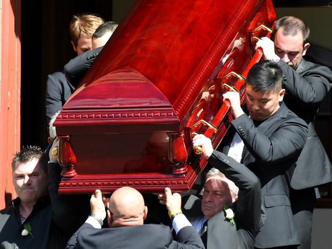 Karen's brother and husband help guide the coffin down the church’s steps. Picture: Nicole Garmston