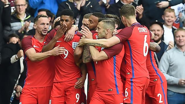 England's striker Marcus Rashford (2nd L) celebrates after scoring.