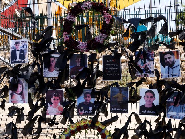 Portraits of the children who were killed hang on the football stadium fence where a rocket landed, in the Druze village of Majdal Shams. Picture: AFP