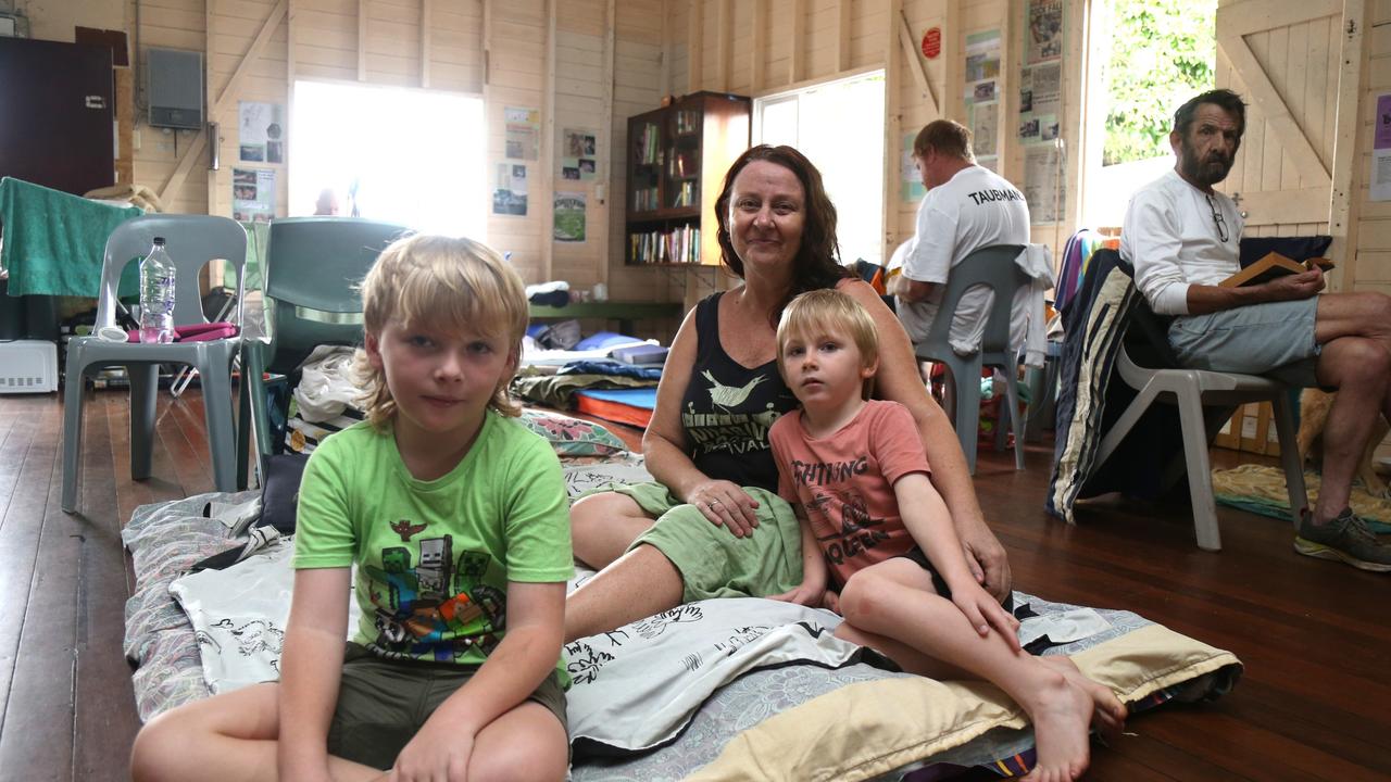 Tracy Walker with Tyler and Roman Archer evacuated to the Machans Beach Community Hall after their house was inundated by flood water. Picture: Peter Carruthers