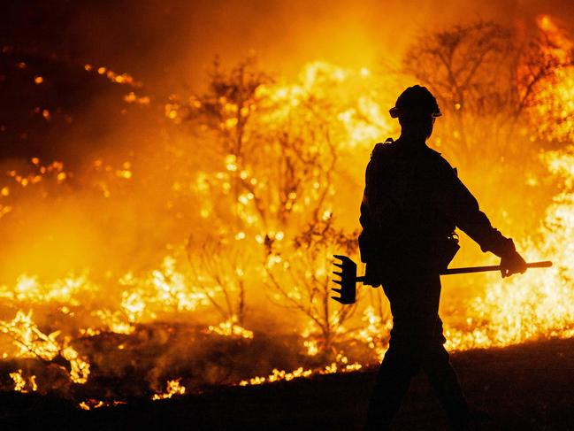 CASTAIC, CALIFORNIA - JANUARY 22: (EDITOR'S NOTE: Alternate crop) A firefighter works as the Hughes Fire burns on January 22, 2025 in Castaic, California. The wildfire has spread 9,400 acres and has prompted mandatory evacuations just over two weeks after the Eaton and Palisades Fires caused widespread destruction across Los Angeles County.   Brandon Bell/Getty Images/AFP (Photo by Brandon Bell / GETTY IMAGES NORTH AMERICA / Getty Images via AFP)