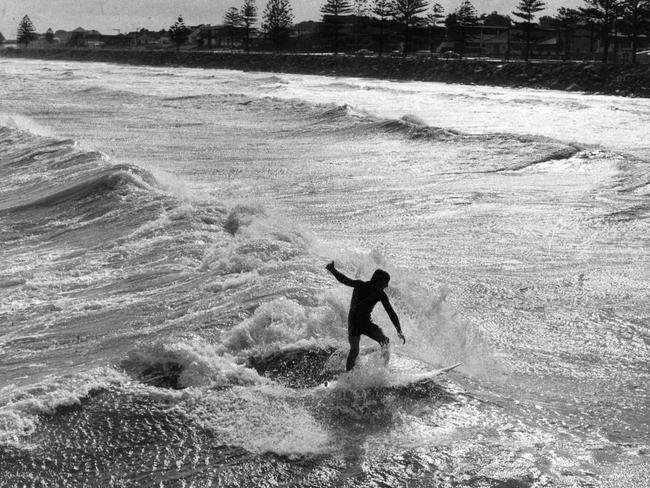 Lone surfer Ashley Dwiar, 15, of Brighton, takes advantage of storm-swept seas which pounded Brighton beach, South Australia, in 1980. (Pic: Adelaide Advertiser)