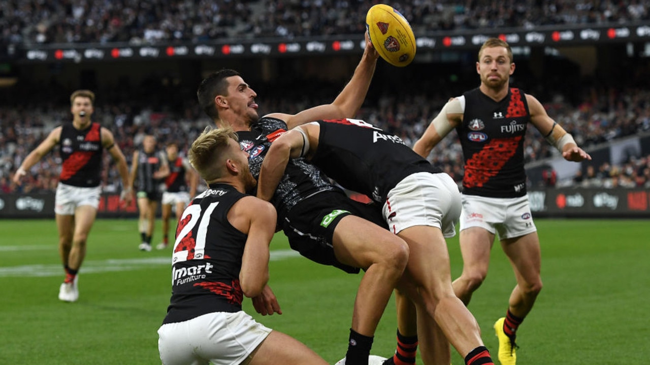 MELBOURNE, AUSTRALIA - APRIL 25: Scott Pendlebury of the Magpies is tackled by Dyson Heppell and Kyle Langford of the Bombers during the round six AFL match between the Collingwood Magpies and the Essendon Bombers at Melbourne Cricket Ground on April 25, 2021 in Melbourne, Australia. (Photo by Quinn Rooney/Getty Images)