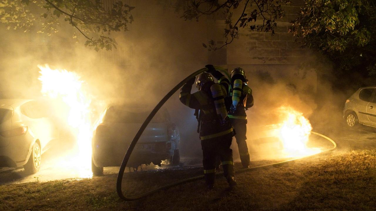 Firefighters put out the flames on a vehicle set on fire during violent protests in Tours. (Photo by GUILLAUME SOUVANT / AFP)